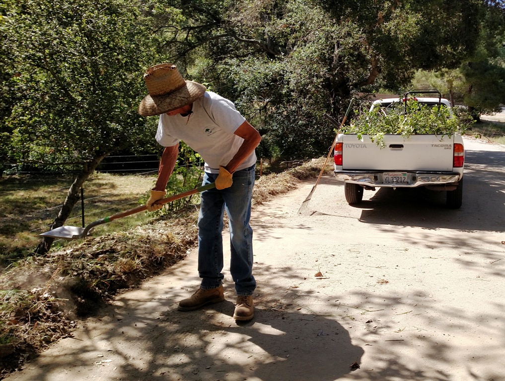 Phil cleaning up dried mud off the trail head pavement!